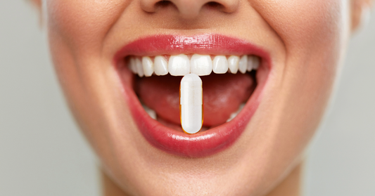 A close up image of a peptide capsule between a woman's smile emphasizing peptide capsules for health and wellness