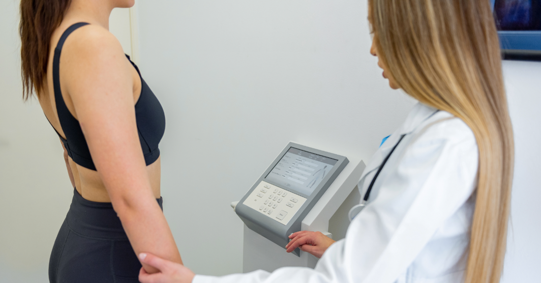 An image of a woman standing on a body composition scanner and talking with a health care professional emphasizing how peptides such as GH-Release CJC-1295 can improve body composition without hormone therapy